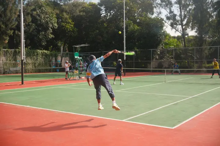 A player stretching for a smash during a match on an outdoor court